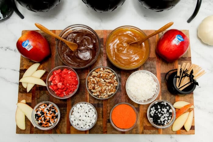 Platter of Jazz™ apple slices with Halloween toppings like sprinkles, candy eyes, and caramel sauce